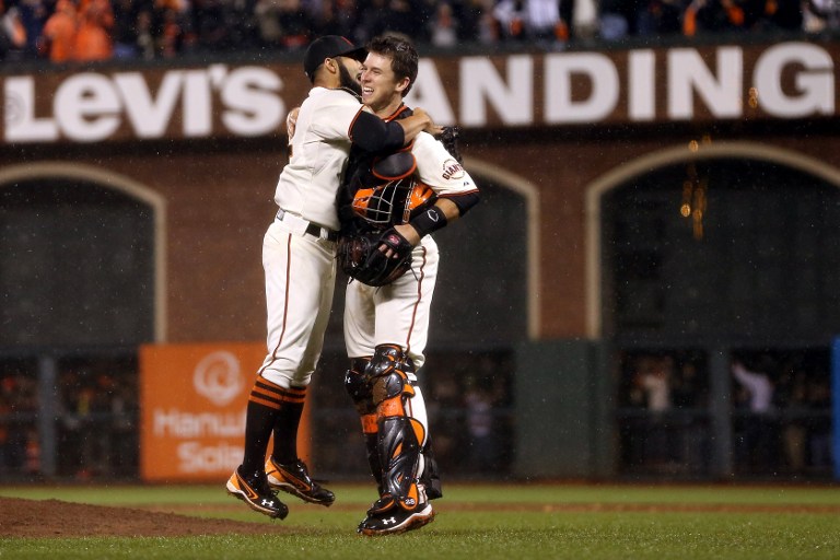 QUITE A WIN. Pitcher Sergio Romo #54 and catcher Buster Posey #28 of the San Francisco Giants celebrate after the Giants defeat the St. Louis Cardinals 9-0 in Game Seven of the National League Championship Series at AT&T Park 