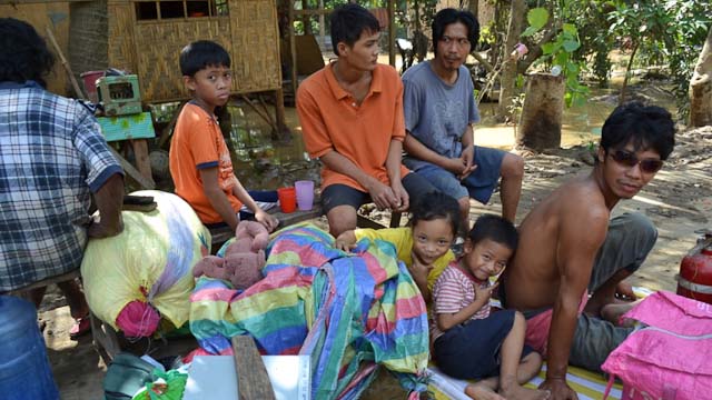EVACUEES. A family leaves their home with pots and pans and other possessions.