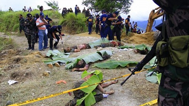 MASSACRE. Police investigators check dead bodies covered with banana leaves, victims of a massacre in the town of Ampatuan, Maguindanao province. AFP file photo