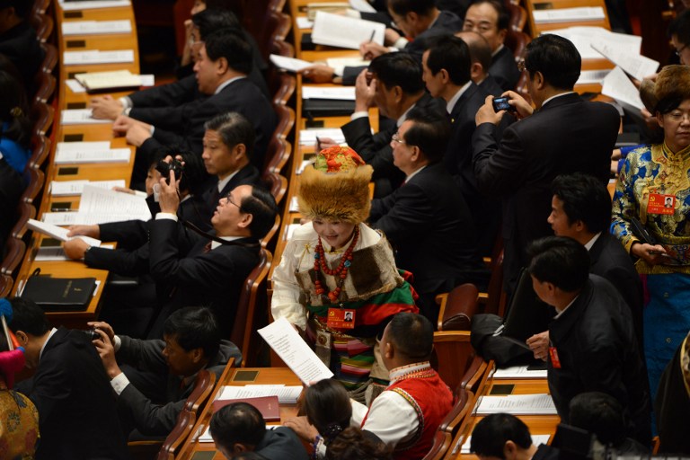 A delegate wearing a ethnic clothing presents forms at the opening of the 18th Communist Party Congress at the Great Hall of the People in Beijing on November 8, 2012. AFP PHOTO/WANG ZHAO