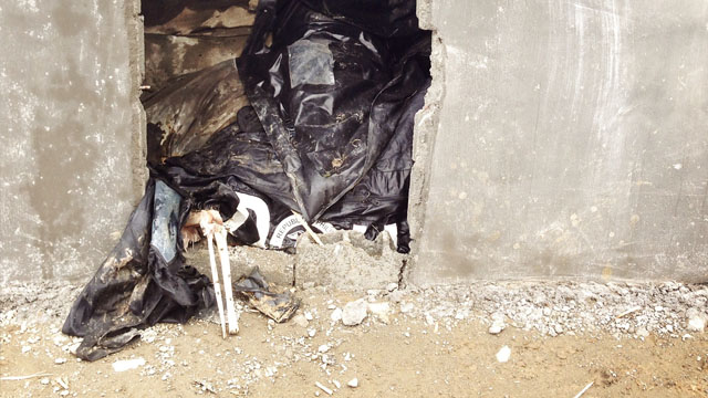 Bones stick out of a body bag in one of the newly-built crypts in New Bataan, Compostela Valley. Photo by John Javellana 25 Dec 2012.