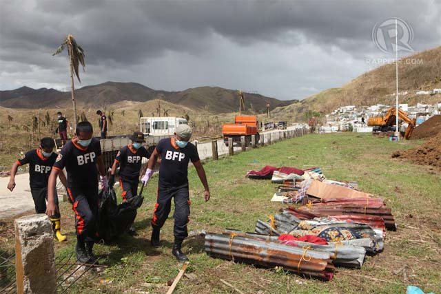 PALLBEARERS. Members of the Bureau of Fire Protection carry unidentified cadavers to the city's first mass grave. File photo by Jake Verzosa