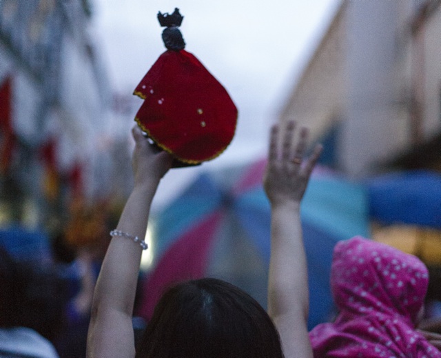 ALL PRAISE. A lady raises her Sto. Niño statue during the procession
