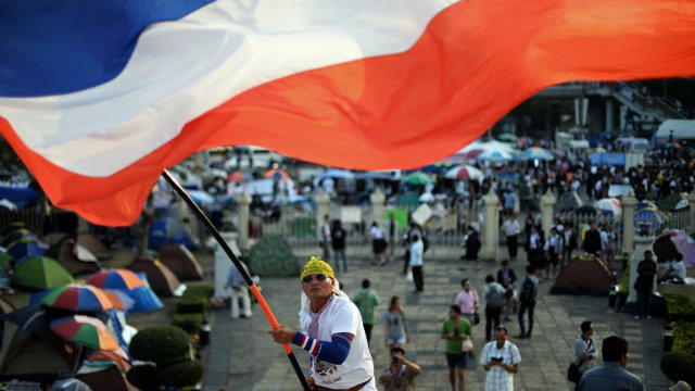 PROTESTER. A Thai anti-government protester waves a national flag during ongoing rallies at a protest site at Victory Monument in downtown Bangkok on January 24, 2014. Photo by Christophe Archambault/AFP