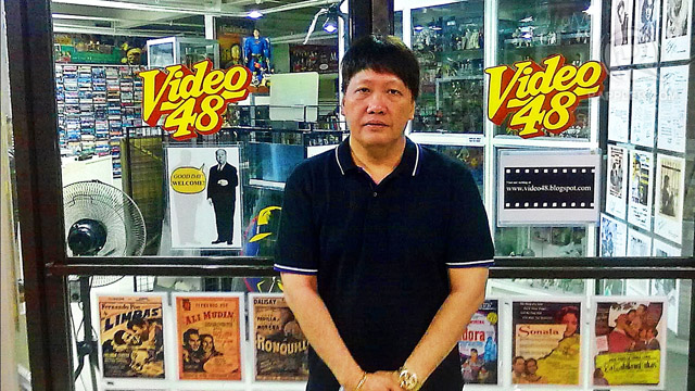THE FILM MAN. Santos stands at