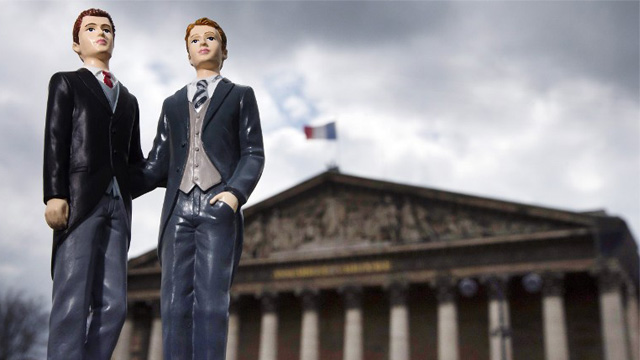 FRANCE, Paris : Picture taken on April 23, 2013 in Paris shows an illustration made with plastic figurines of men in front of the Palais Bourbon, the seat of the French National Assembly. After months of acrimonious debate and hundreds of protests that have occasionally spilled over into violence, France's National Assembly is due to approve today a bill making the country the 14th to legalise same-sex marriage. AFP PHOTO / JOEL SAGET