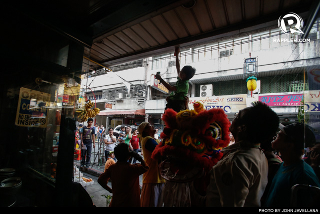 'FEED' THE DRAGON. Another Dragon Lion performer reaches for an 'ampao' donation, this time in a restaurant in Chinatown 