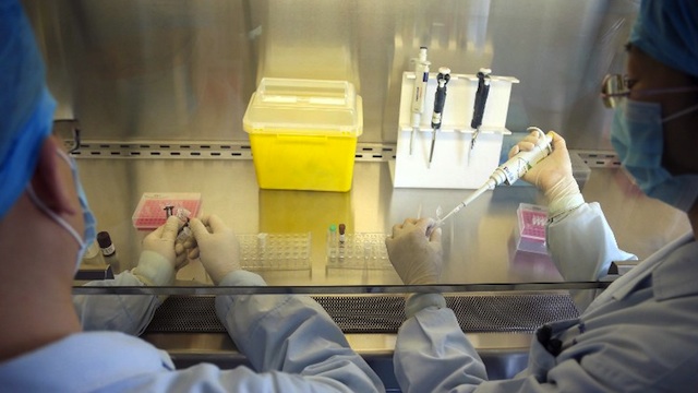 FLU TESTING. This picture taken on April 3, 2013 shows Chinese health workers preparing an H7N9 virus detection kit at the Center for Disease Control (CDC) in Beijing. AFP PHOTO