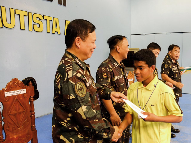 SURRENDER: Jong Manlantagan, 17, receives from AFP Chief General Emmanuel Bautista compensation for the firearm he surrendered to the Philippine Army. Photo by Bobby Lagsa