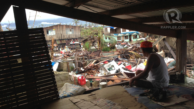 A resident looks out a makeshift roof built atop his house that was severely damaged by typhoon Bopha, locally known as "Pablo"  in the town of Cateel, Davao Oriental December 31, 2012. Thousands of residents dependent on aid and relief to sustain themselves are currently struggling to rebuild their homes and livelihood that were devastated by the typhoon which made landfall last December 4, 2012. Photo by John Javellana.