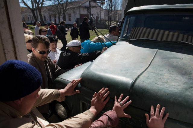 REAKING IN. Pro-Russian protesters push away a truck blocking the entrance to a Ukrainian air force base as they storm the building in the small city of Novofedorivka, in the Saki district of western Crimea. Photo by Dmitry Serebryakov/AFP