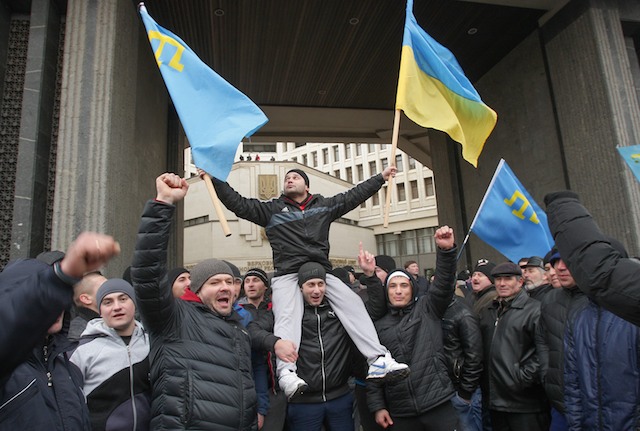 UKRAINE, NOT RUSSIA. Activists hold Crimean Tatar (C-L) and Ukrainian national flags (C-R) as they shout slogans such as 'Crimea is not Russia, Glory to Ukraine' during a rally in Simferopol, Crimea, Ukraine, 26 February 2014. Arthur Shvarts/EPA