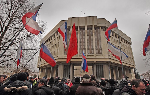 SECESSION? Pro-Russia activists stand with Crimean and Russian flags in front of a building of Crimea autonomy parliament in Simferopol, Ukraine, 27 February 2014. Arthur Shwartz/EPA