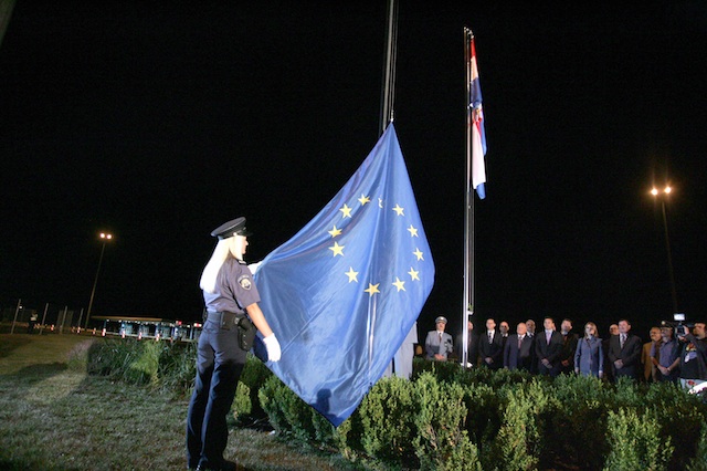 EU'S NEWEST MEMBER. A Croatian police officer hoists the EU flag after Croatia's accession to the European Union, at Bregana border crossing between Croatia and Slovenia, Croatia, early 01 July 2013. EPA/STR