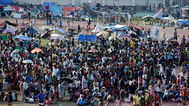 WAITING. Evacuees wait for food supplies inside a football stadium turned into a temporary shelter. Photo by Dennis Sabangan/EPA