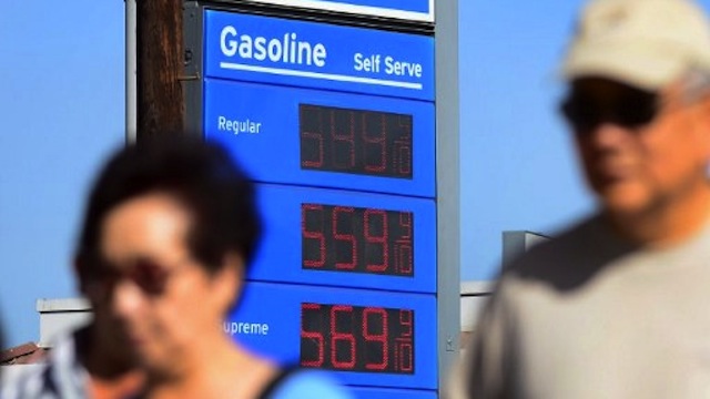 HIGHER OIL PRICES. Pedestrians walk past a gas station in Los Angeles, California. AFP Photo