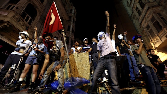 PROTES.  Dalam foto ini, pengunjuk rasa Turki berdiri di barikade dan meneriakkan slogan-slogan anti-pemerintah di Lapangan Taksim, di Istanbul, Turki, 23 Juni 2013. Foto oleh Sedat Suna/EPA