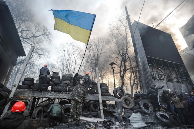 WAR ZONE. A man waves a Ukrainian national flag during an anti-government protest in downtown Kiev, Ukraine, 25 January 2014. Alexey Furman/EPA