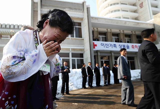 Lim Tae-Wook of North Korea sobs as she leaves her South Korean older brother. Photo by Lee Ji-Eun/EPA/South Korea Out