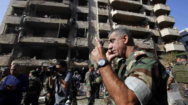 BLAST ZONE. A member of the Lebanese army talks on the phone at the site of a blast in Bir Hassan neighborhood in southern Beirut on November 19, 2013. Photo by Anwar Amro/AFP