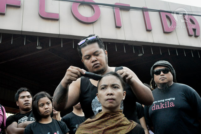 SHAVING FOR JUSTICE. A member of the artist group Dakila shaves the head of Leiz Jimenez widow of the late activist-entertainer Arvin 'Tado' Jimenez in front of the GV Florida bus station in Sampaloc, Manila Febuary 19, 2014. Photo by LeAnne Jazul/Rappler