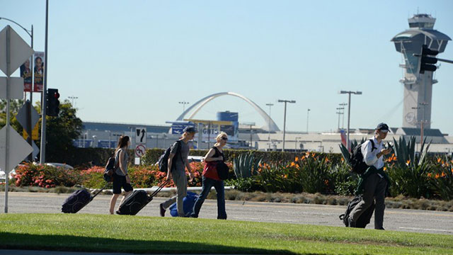 EVACUATION. Passengers carry their bags at Los Angeles International Airport on November 1, 2013 after a gunman reportedly shot 3 people at a security checkpoint. File photo by Robyn Beck/AFP