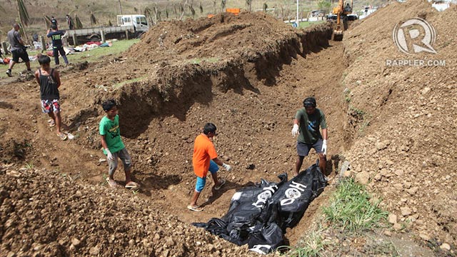 TEMPORARY. Authorities start burying the dead in Tacloban City. File photo by Jake Verzosa