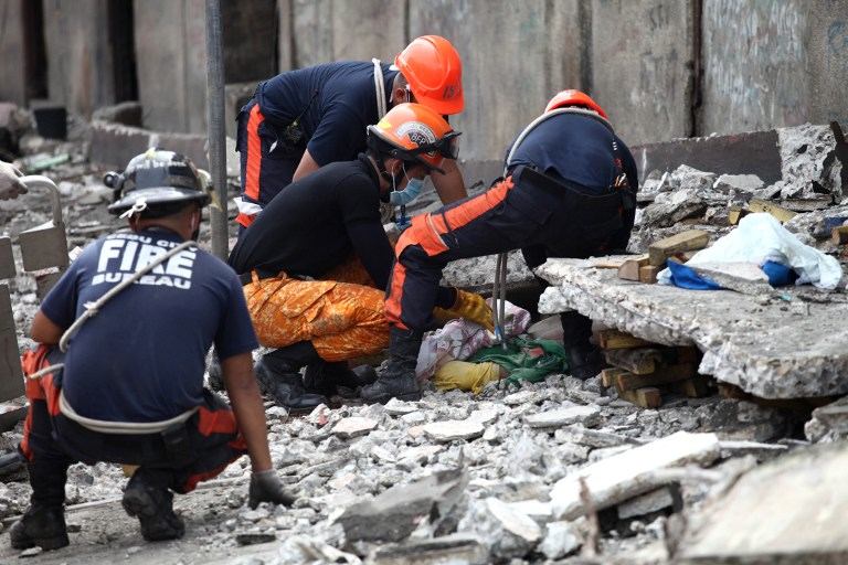 CASUALTY. Rescuers try to uncover an unidentified man under slabs of cement in Cebu City, Philippines after a major 7.1 magnitude earthquake struck the region on October 15, 2013. AFP/Chester Baldicanto