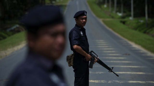 MILITANTS SURROUNDED. Malaysian armed policemen man a security check in Sahabat 7 on the road leading to Tanjung Tanduo, in the areas where suspected Philippine militants are holding off on the Malaysian island of Borneo on February 18, 2013. AFP PHOTO / MOHD RASFAN
