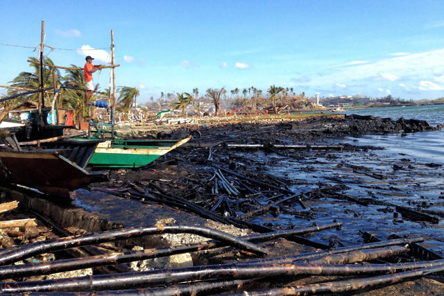 COVERED IN OIL. Logs and other pieces of wood covered along the shoreline of Barangay Botongon in Estancia town. File photo by Jonathan Jurilla, Typhoon Yolanda Story Hub Visayas