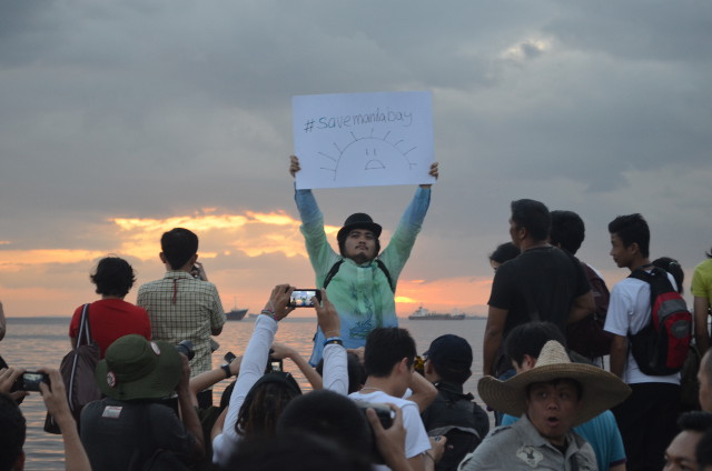 A LA CARLOS. Sunset watcher Jomar Carpena takes his stance for the Manila Bay sunset. Photo by Melinda Gabuya
