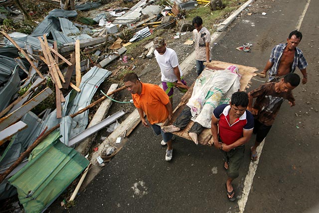 RETRIEVAL. Dead bodies litter the streets of Tacloban city as volunteers collect them. Photo by EPA/Francis Malasig