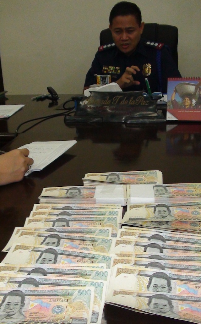 FAKE MONEY. Senior Supt. Ricardo de la Paz, Negros Occidental police officer-in-charge, presents the P150,000 worth of fake P500 bills. Rappler/Gilbert Bayoran